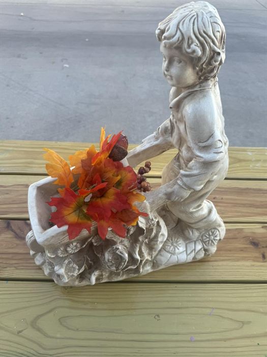 Seated plaster cherub holding a vessel