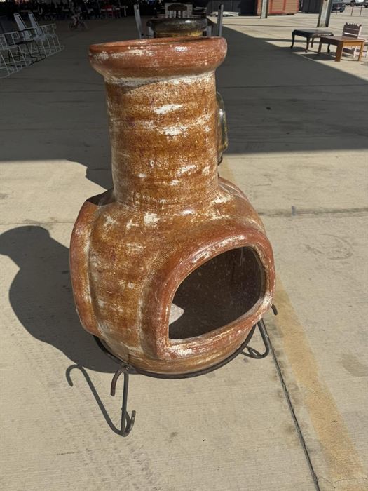 Amber glazed clay chiminea on an iron stand