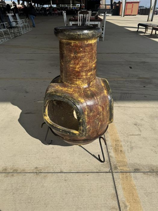 Small glazed clay chiminea on an iron stand