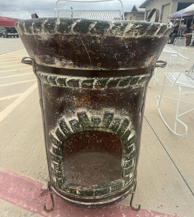 Fired clay chiminea with a fluted rim on an iron stand