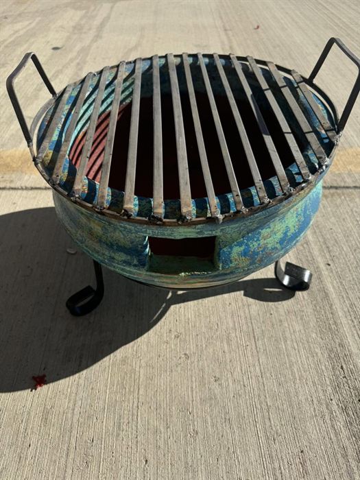 Steel fire pit with a glazed rim and grate top
