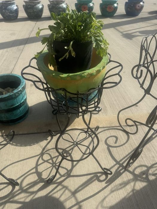 Wrought iron plant stand holding a planted pot