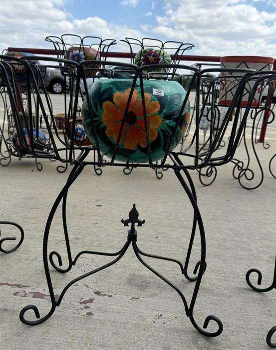 Tiered wrought iron plant stand holding three talavera pots