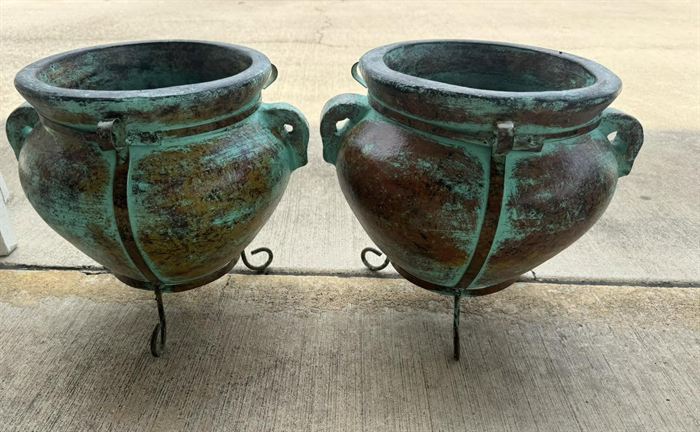 A pair of large glazed urns on iron stands