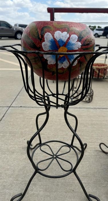 Wrought iron stand holding a painted earthenware bowl