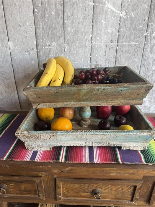 A pair of weathered wood serving trays on a woven serape